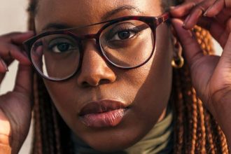 Jeune femme essayant des lunettes de vue dans un magasin