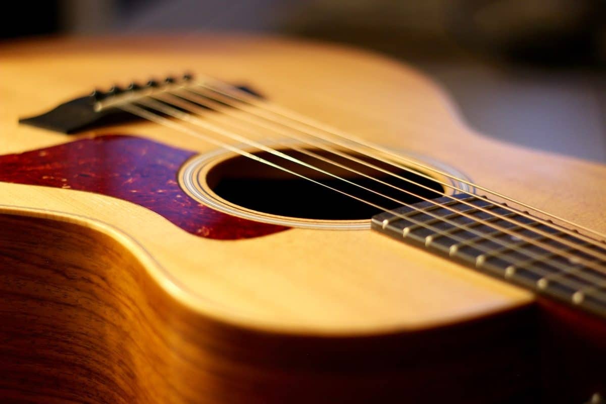selective focus photography of brown wooden dreadnought acoustic guitar